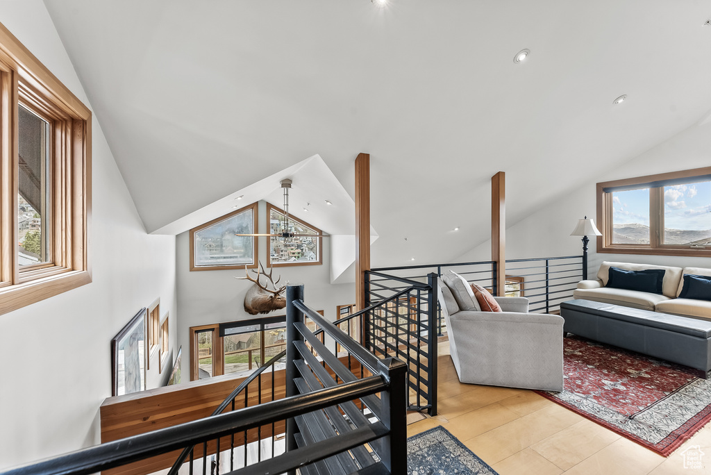 Staircase with plenty of natural light, a chandelier, and light tile floors