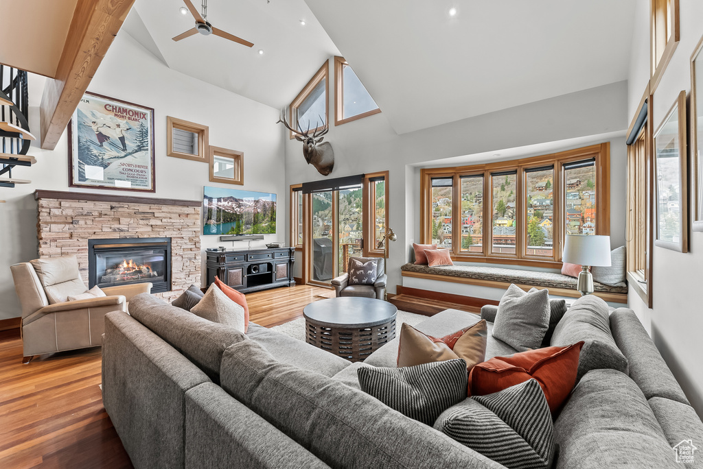 Living room featuring high vaulted ceiling, a fireplace, and plenty of natural light