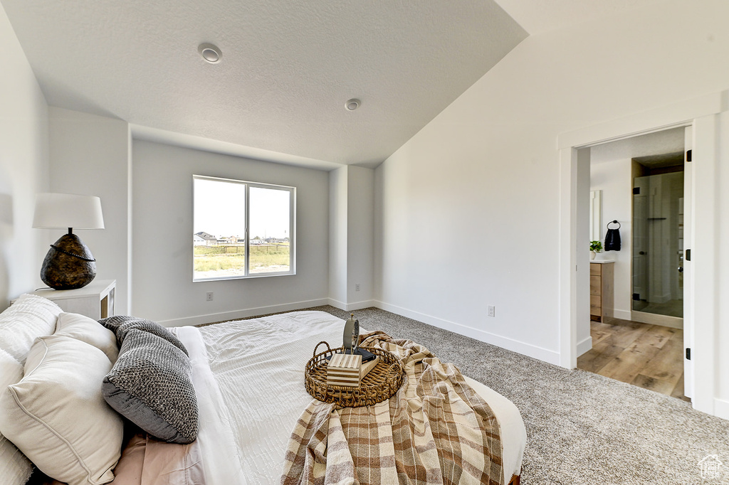 Bedroom featuring vaulted ceiling and light wood-type flooring