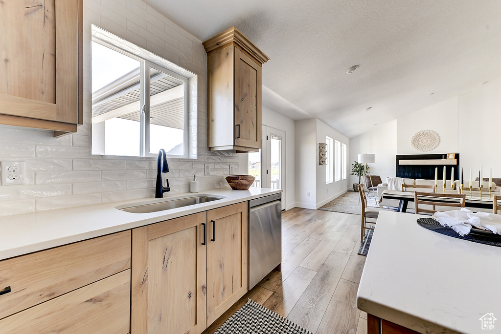 Kitchen featuring dishwasher, light hardwood / wood-style floors, sink, light brown cabinets, and decorative backsplash