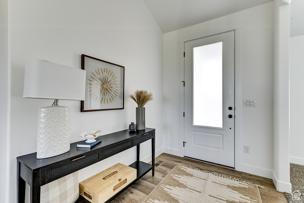 Entrance foyer featuring vaulted ceiling and light hardwood / wood-style floors