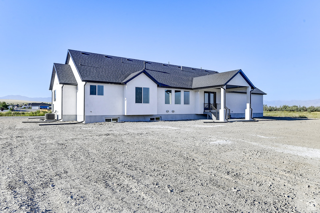 View of front of home with central AC unit and a mountain view