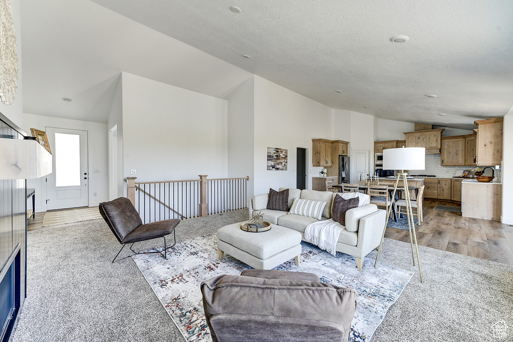 Living room featuring high vaulted ceiling and light wood-type flooring