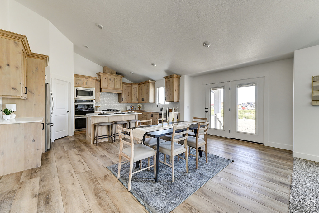 Dining area featuring lofted ceiling and light hardwood / wood-style floors