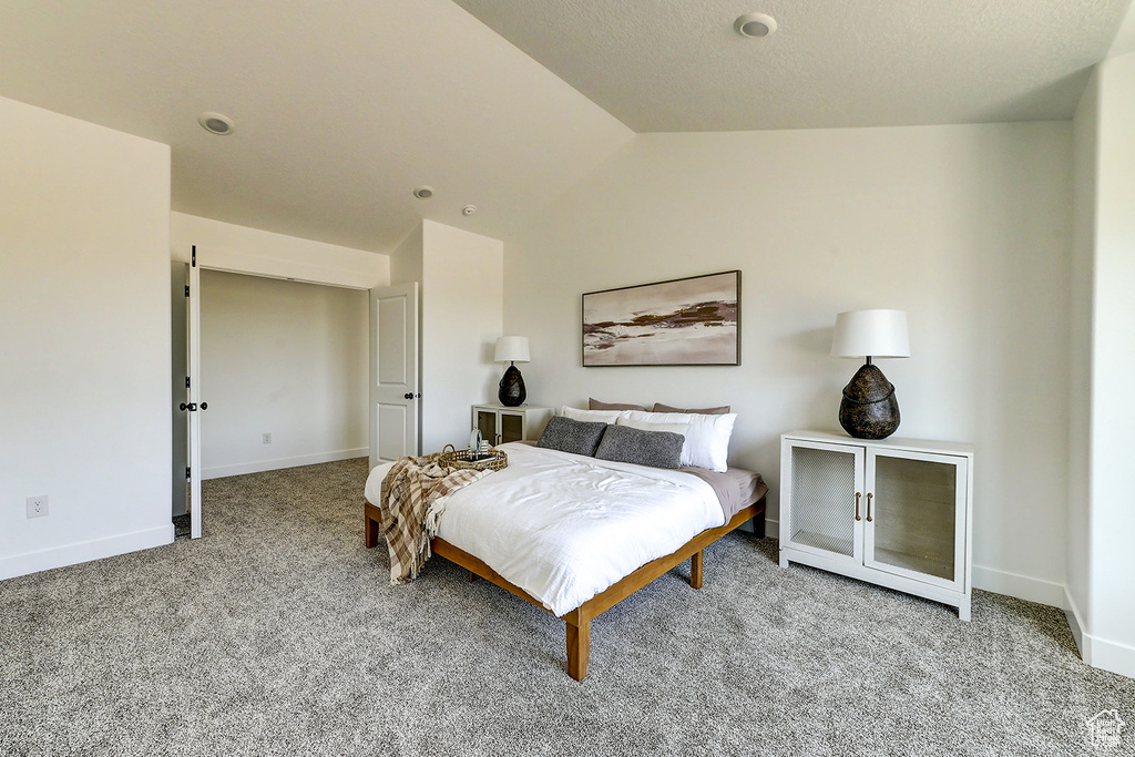 Bedroom with light carpet and vaulted ceiling