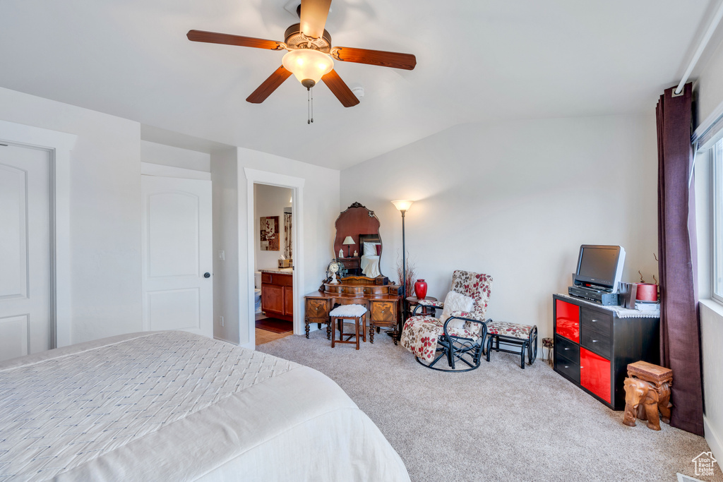 Bedroom with ensuite bath, ceiling fan, vaulted ceiling, and light carpet