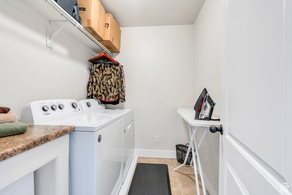 Washroom featuring separate washer and dryer and light tile floors