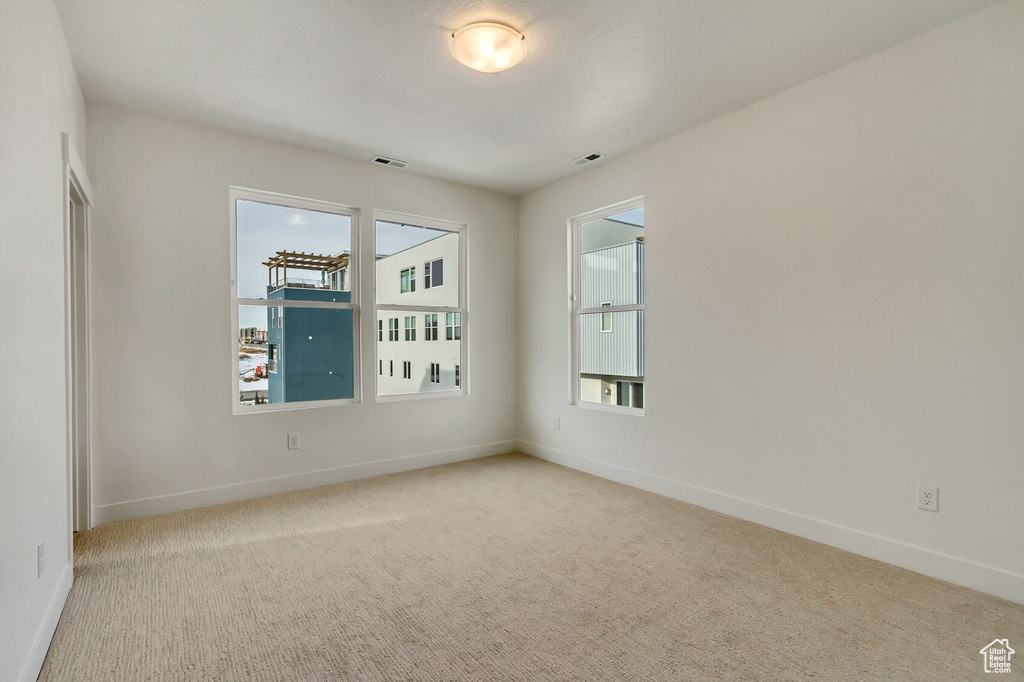 Spare room with a healthy amount of sunlight and light colored carpet