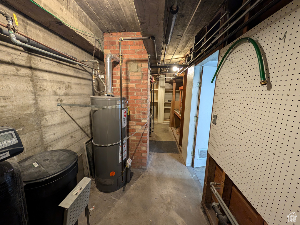 Basement featuring brick wall and water heater