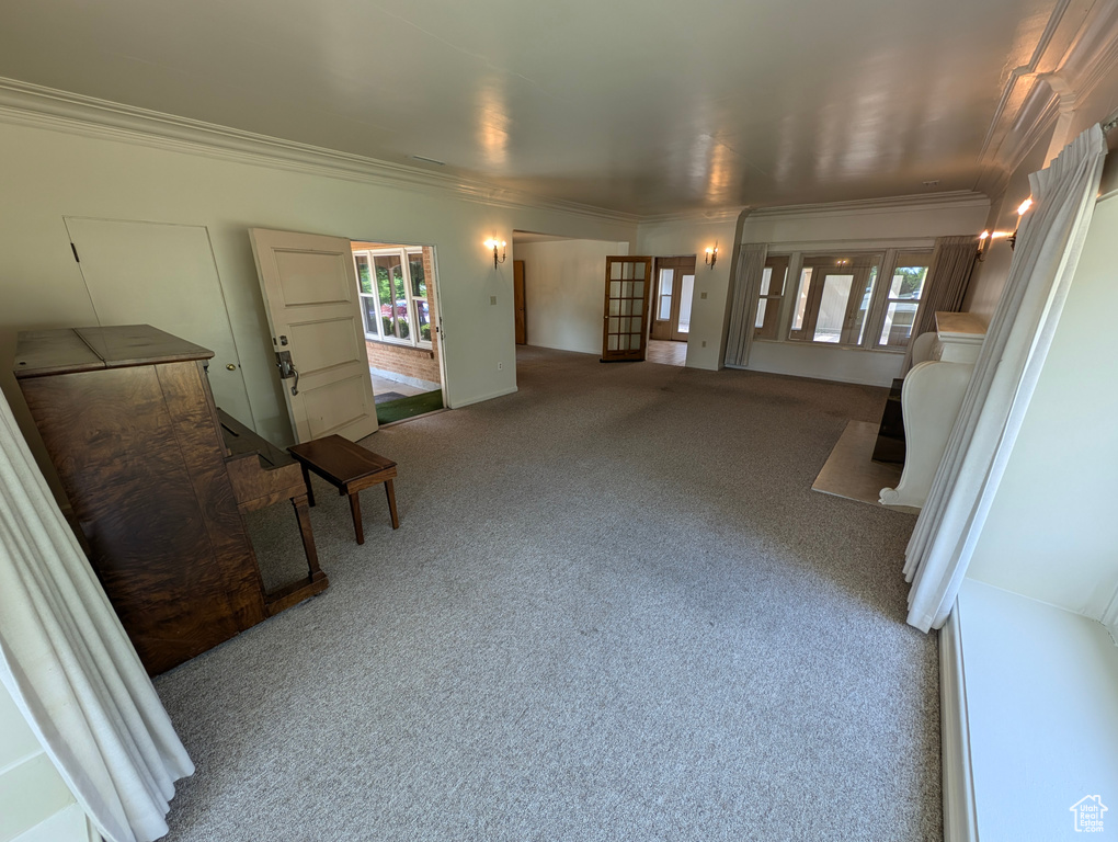 Sitting room featuring a wealth of natural light, carpet flooring, and ornamental molding