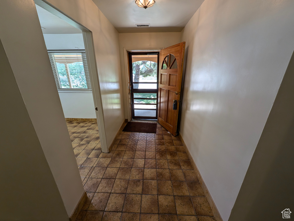 Doorway with dark tile patterned floors