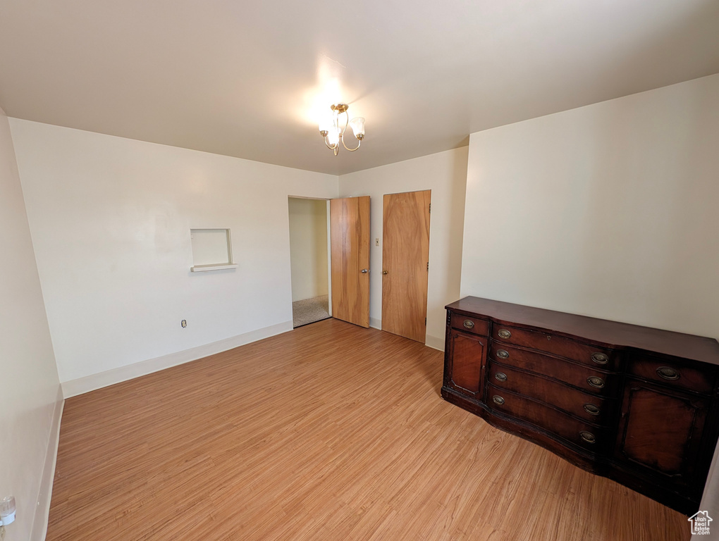 Bedroom featuring light hardwood / wood-style floors and an inviting chandelier