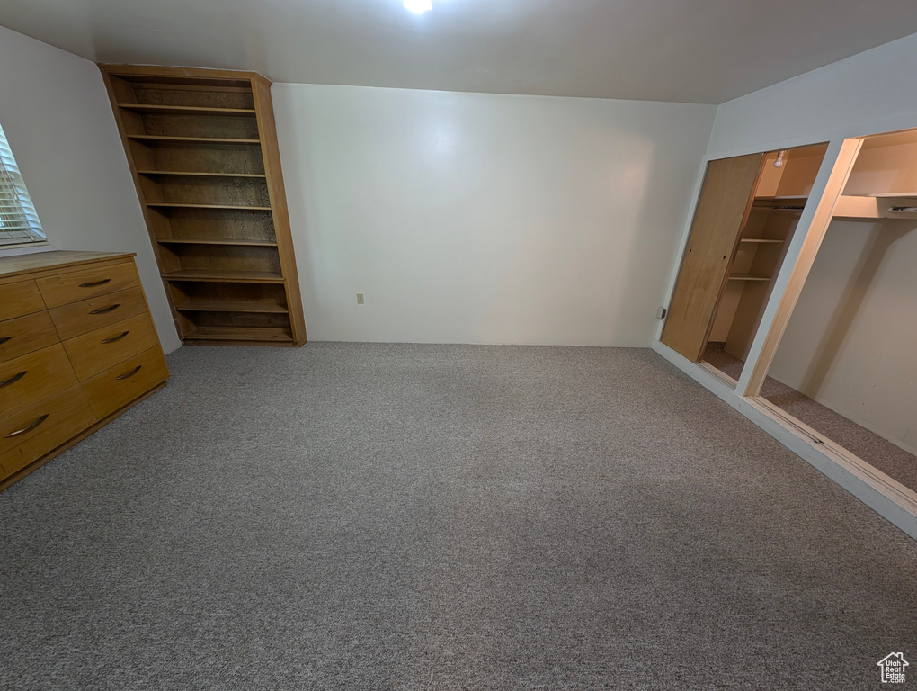 Unfurnished bedroom with carpet, a closet, and a spacious closet