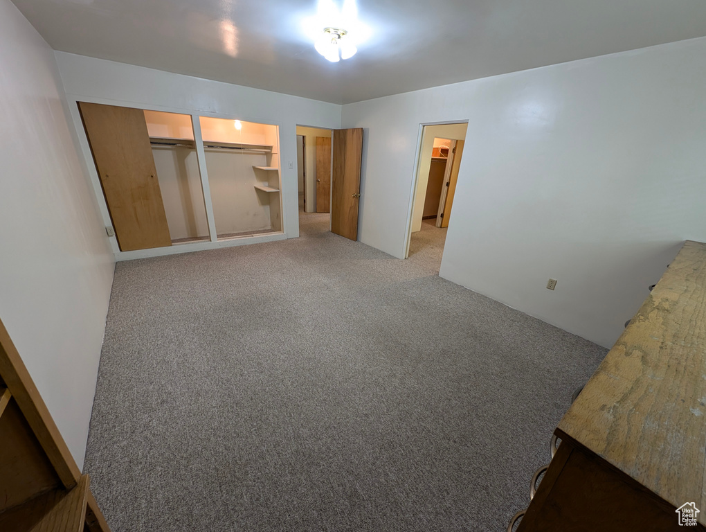 Unfurnished bedroom featuring a closet and light carpet