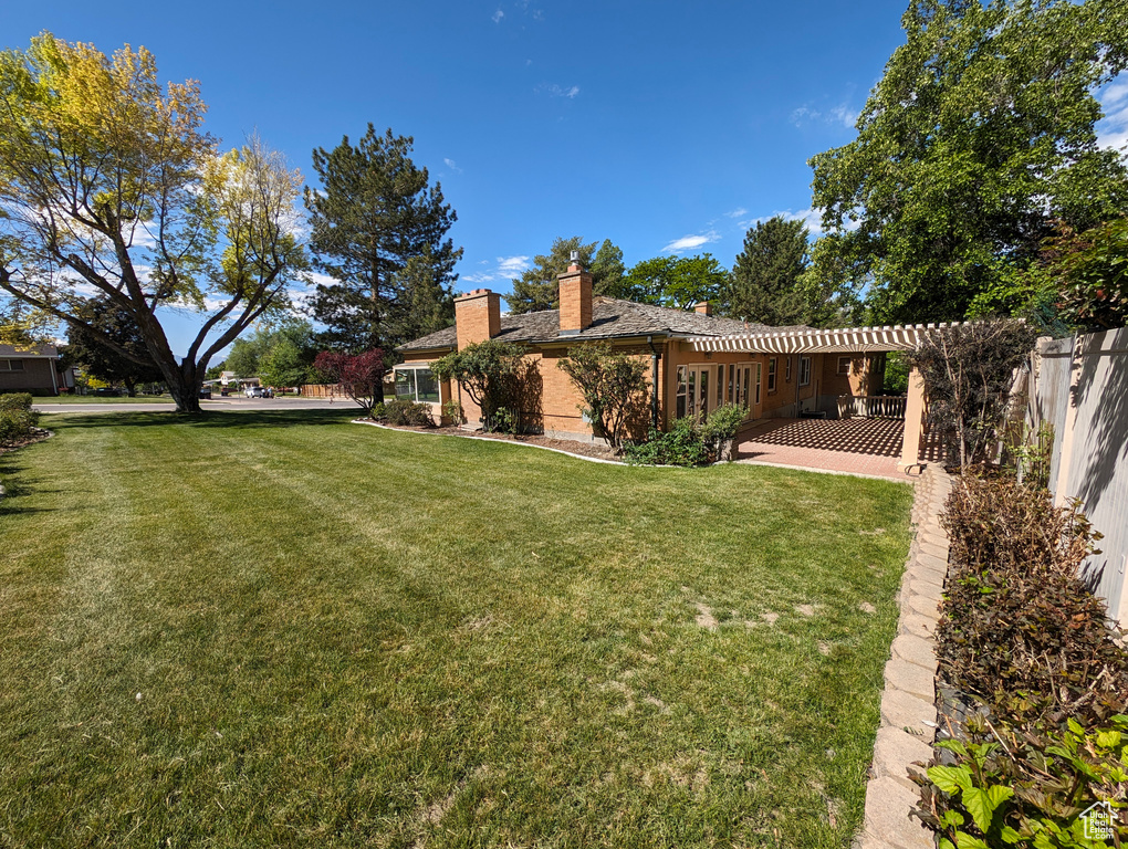 View of yard with a pergola and a patio