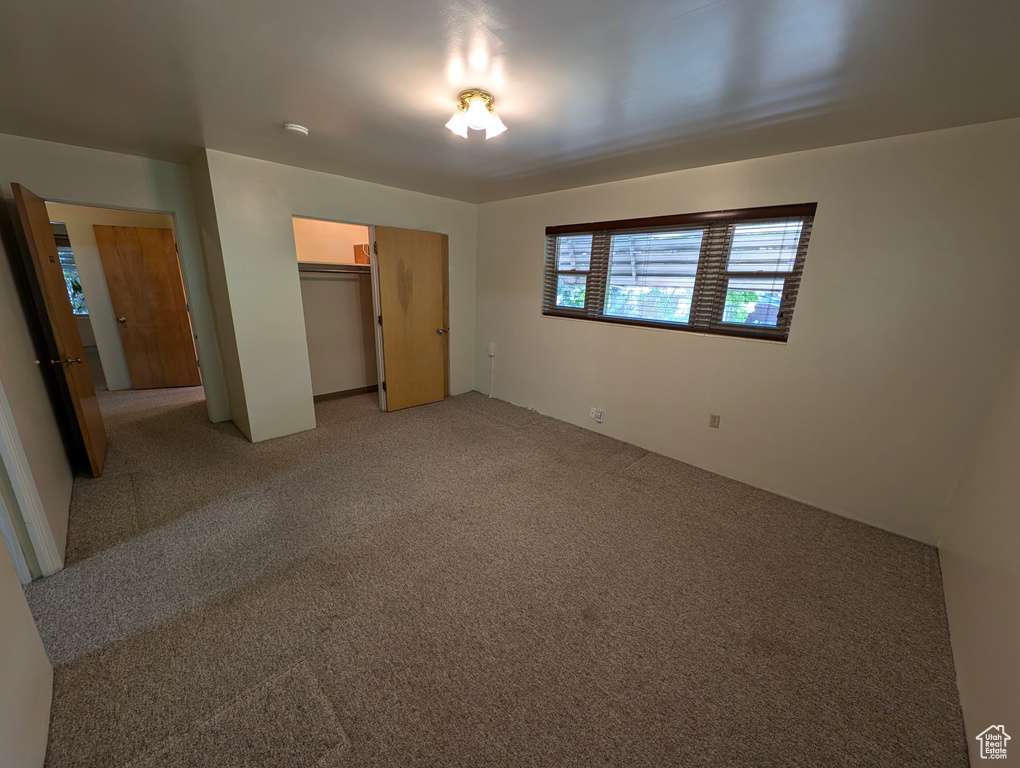 Unfurnished bedroom with light colored carpet