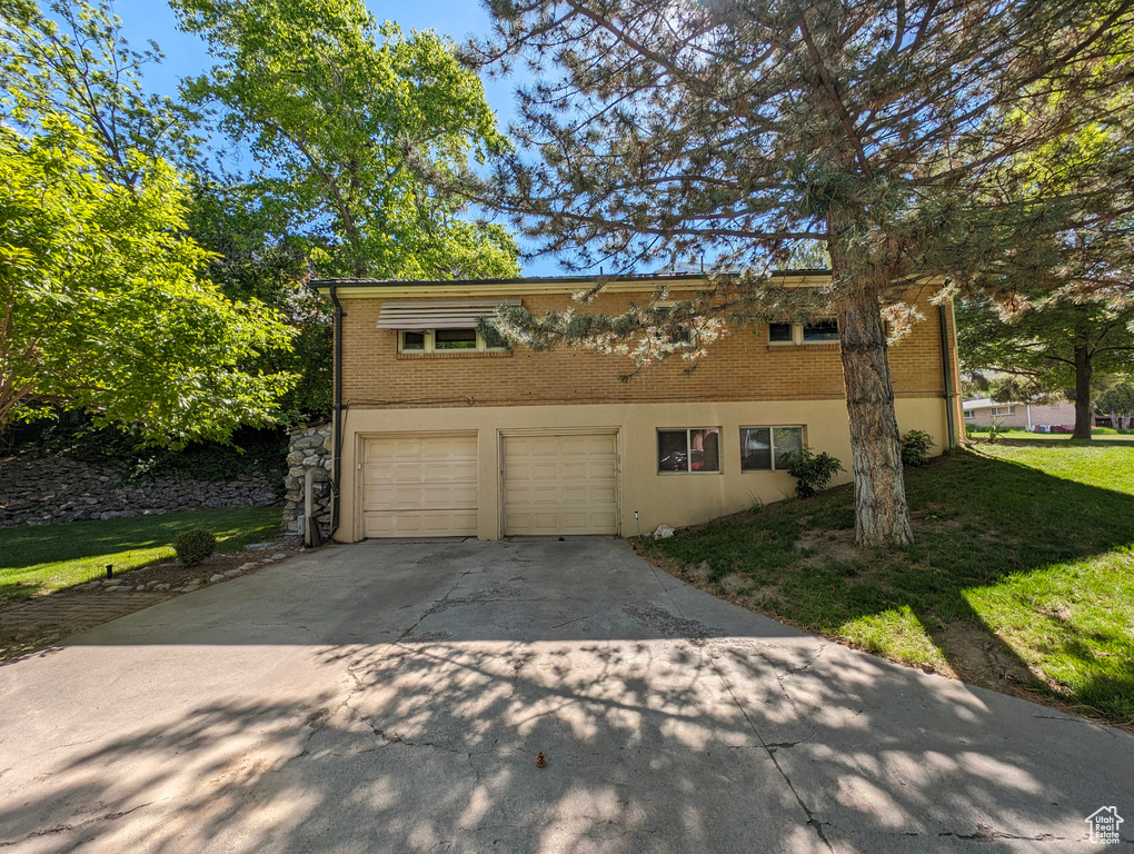 View of front of home with a garage and a front yard