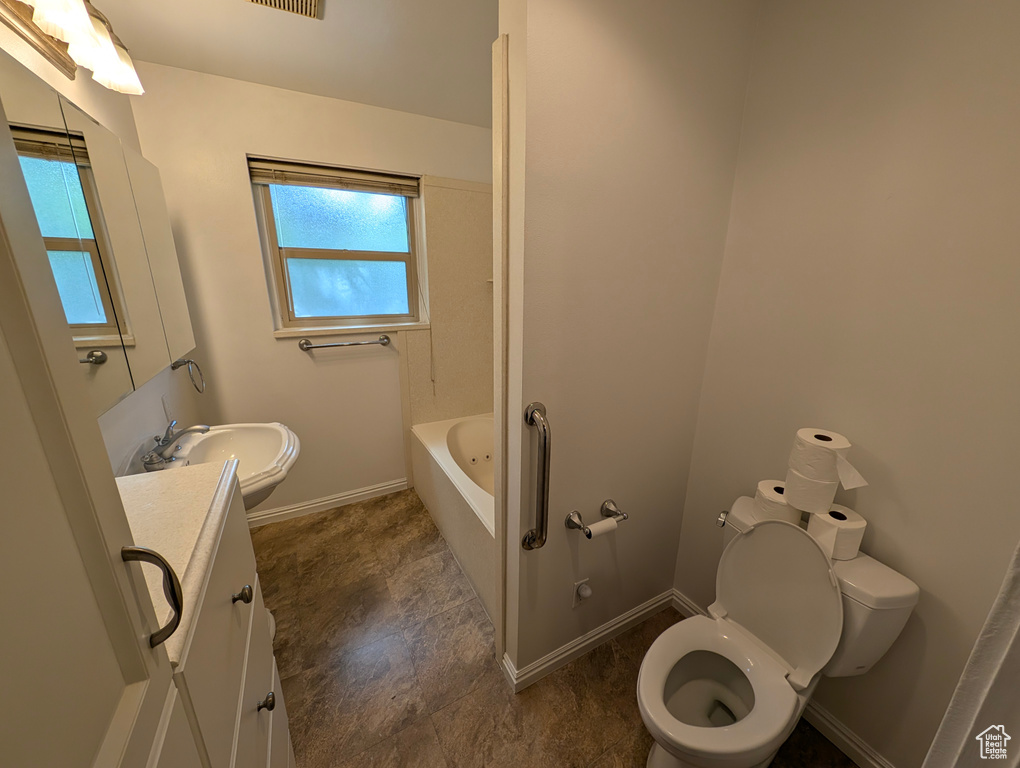 Bathroom featuring a bath, tile patterned floors, vanity, and toilet