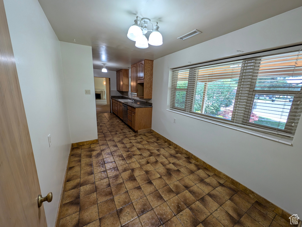 Spare room featuring dark tile patterned flooring, sink, and a chandelier