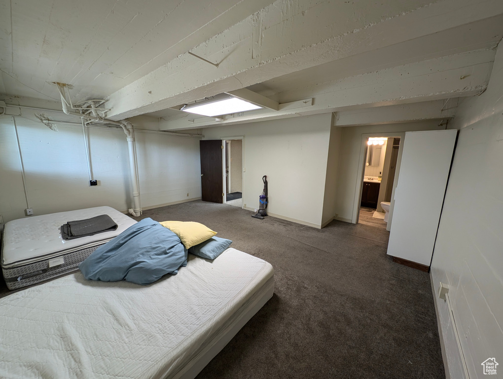 Carpeted bedroom featuring ensuite bathroom