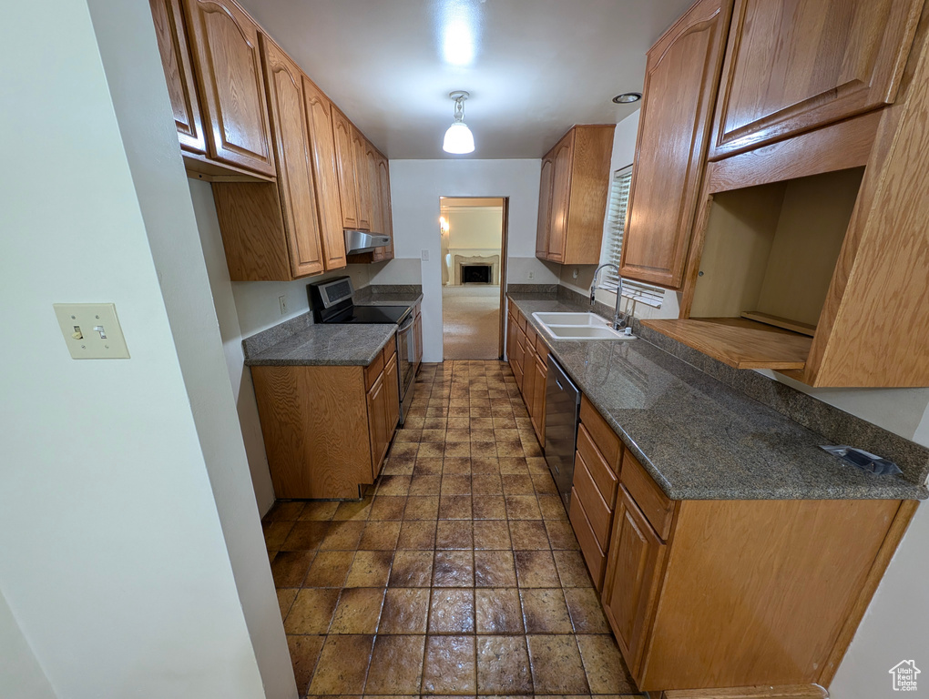 Kitchen with sink, dark tile patterned flooring, and appliances with stainless steel finishes