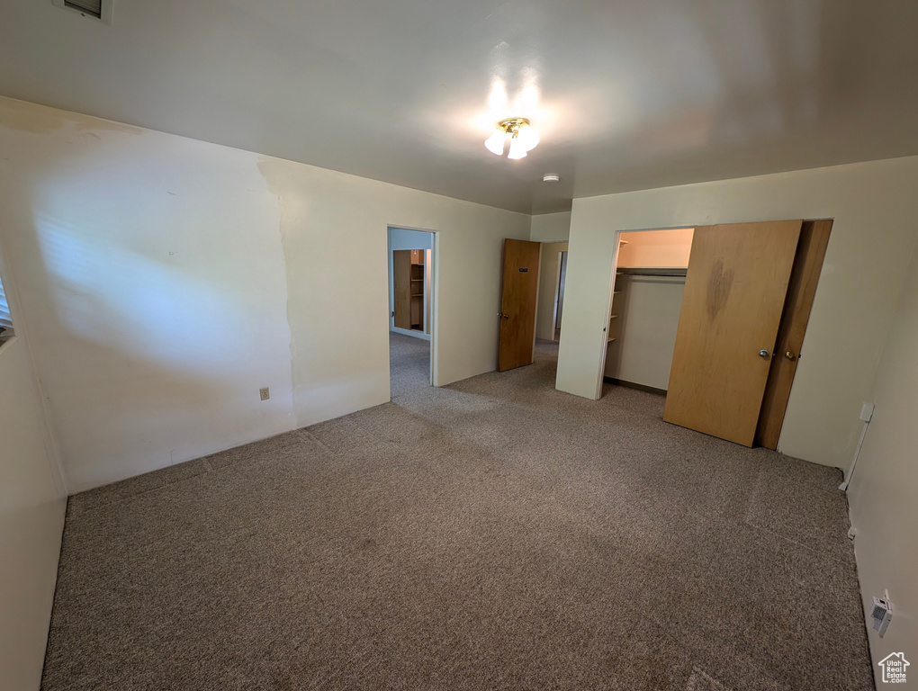 Unfurnished bedroom with a closet and light colored carpet