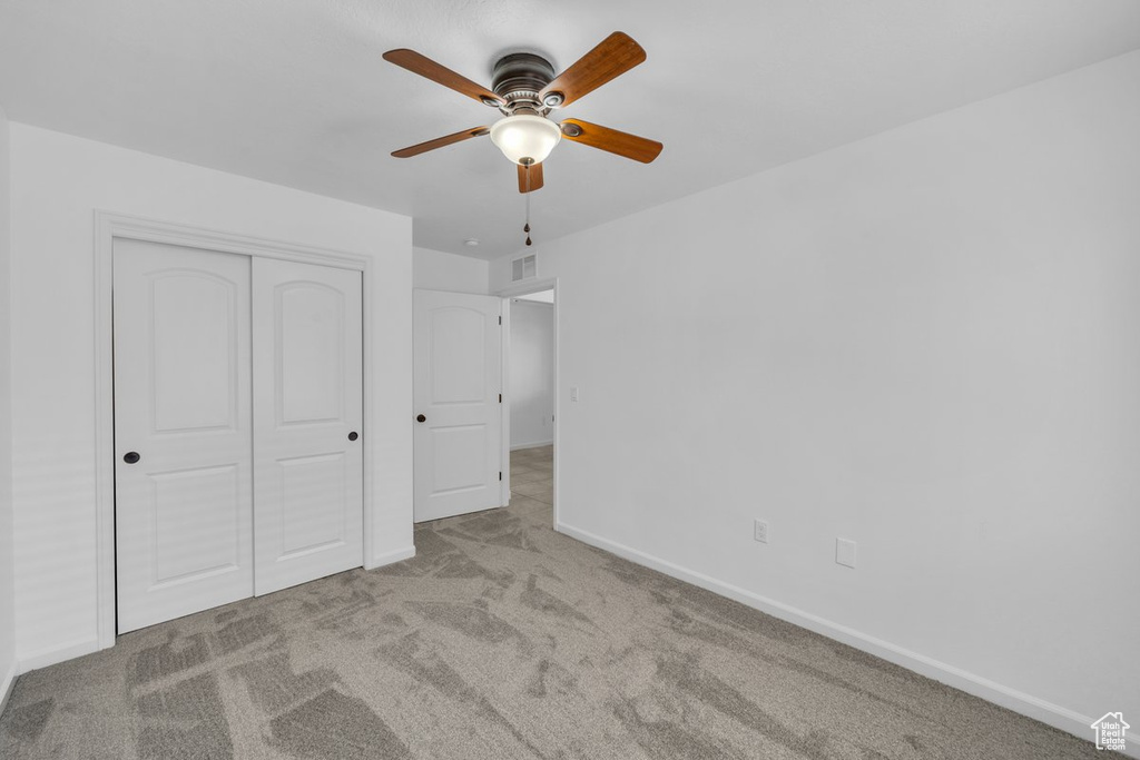 Unfurnished bedroom with carpet flooring, a closet, and ceiling fan