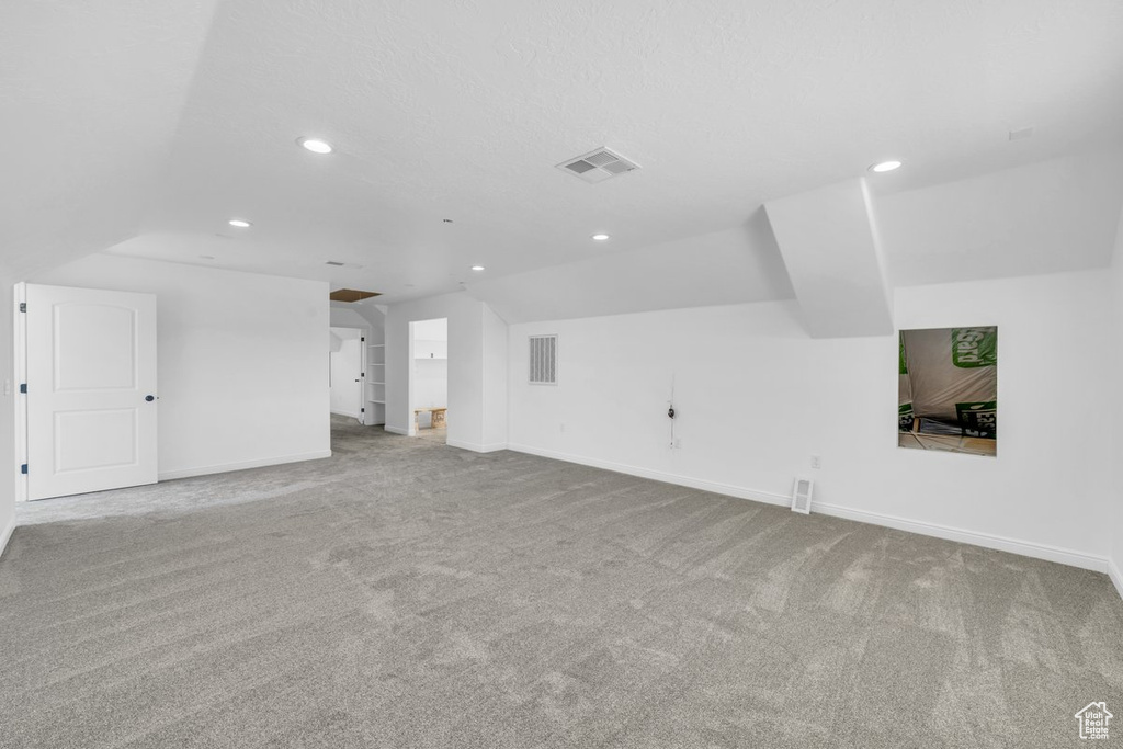Interior space featuring carpet floors and vaulted ceiling