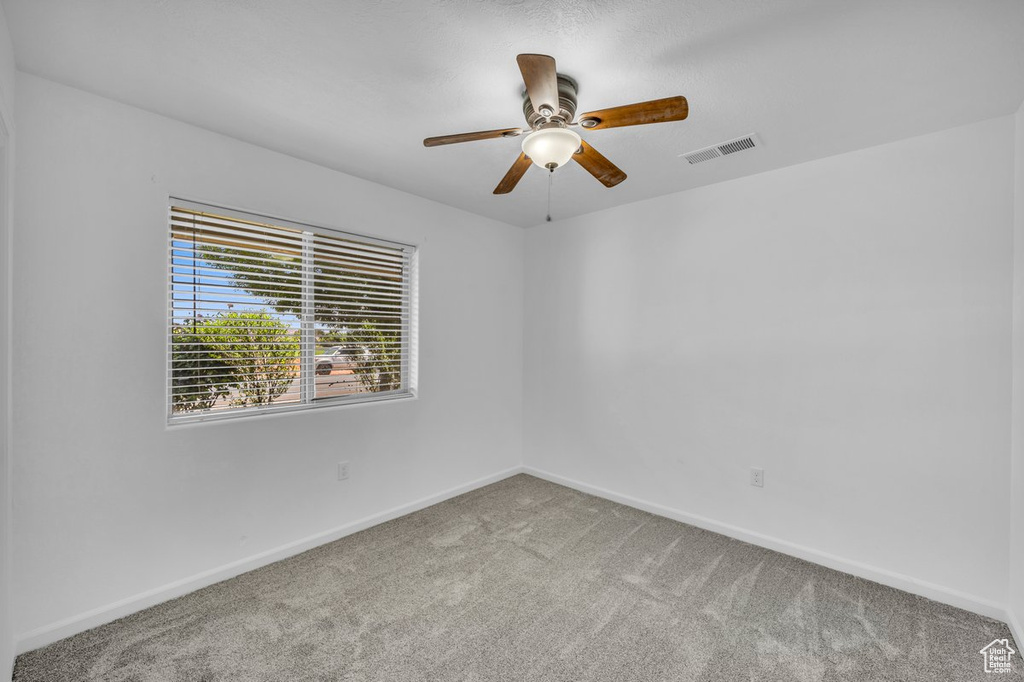 Spare room featuring carpet flooring and ceiling fan