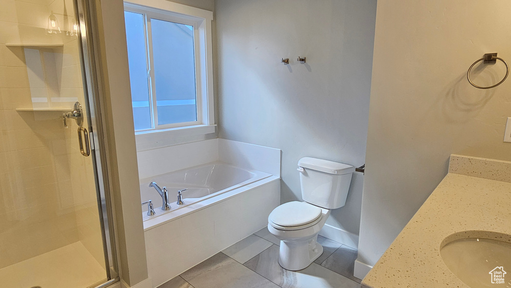 Full bathroom featuring tile patterned flooring, toilet, independent shower and bath, and vanity