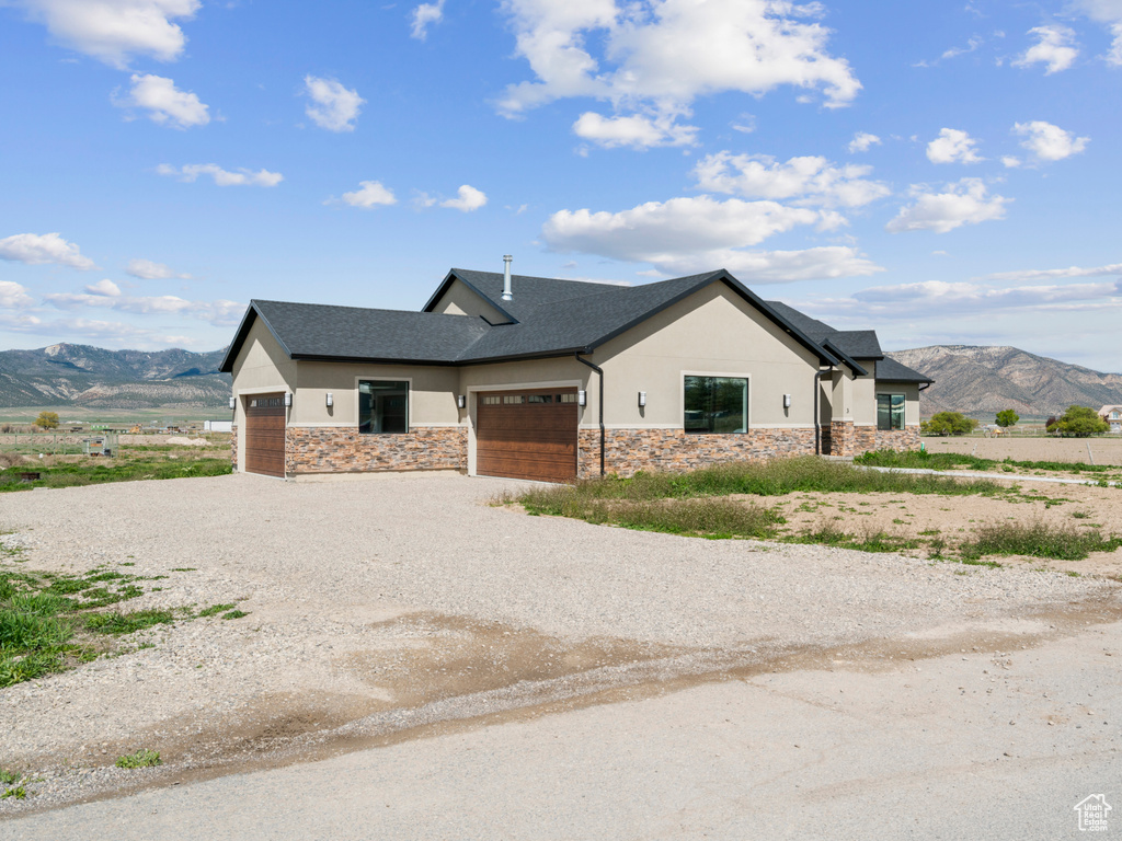 View of front of home with a garage and a mountain view