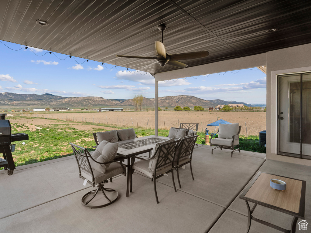 View of terrace with an outdoor living space, a mountain view, and ceiling fan