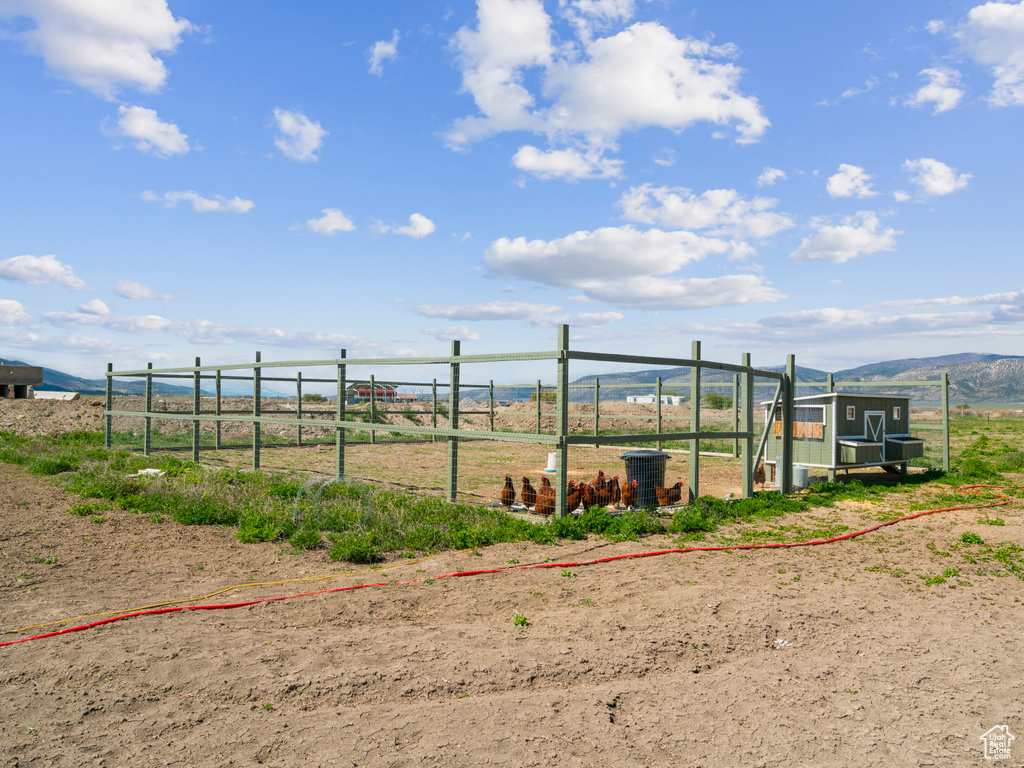 Exterior space with a rural view, an outdoor structure, and a mountain view