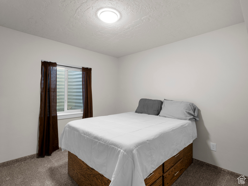 Bedroom featuring a textured ceiling and carpet floors