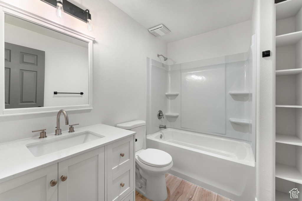 Full bathroom featuring  shower combination, hardwood / wood-style floors, toilet, and vanity