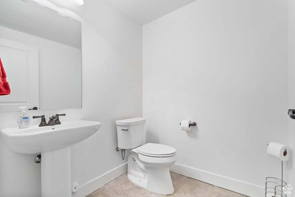 Bathroom with toilet and tile floors