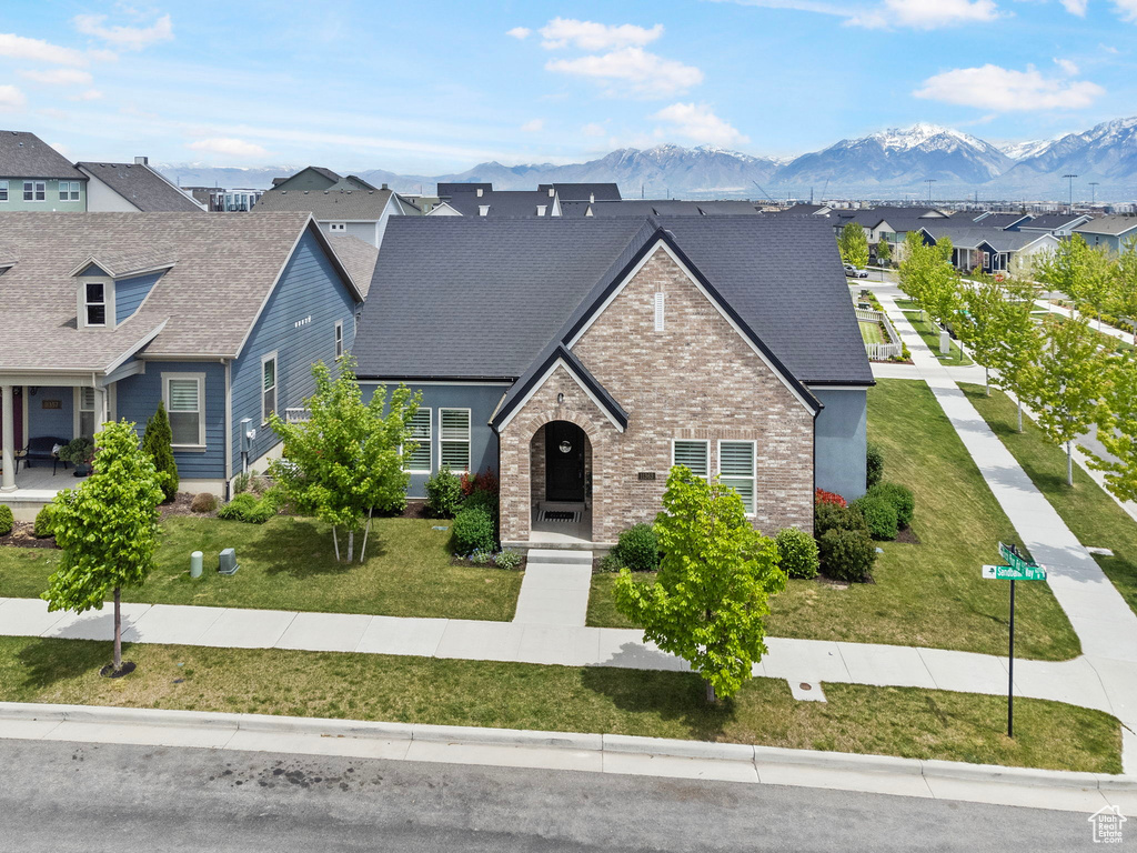 View of front of home with a front yard and a mountain view