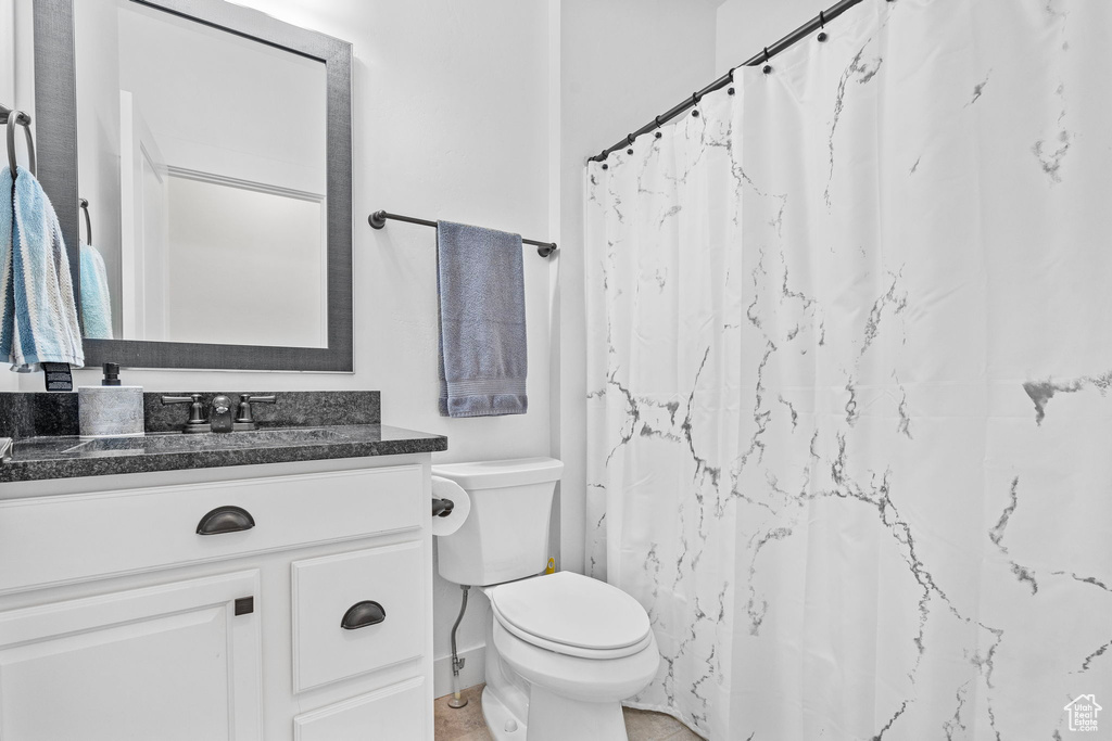 Bathroom with tile flooring, toilet, and vanity