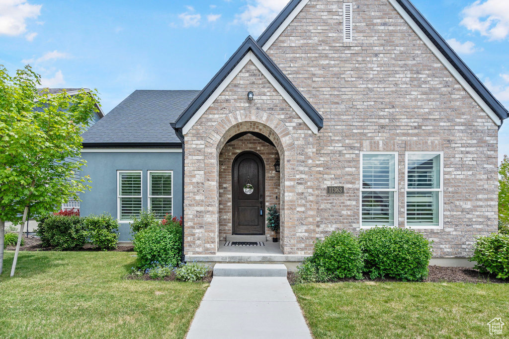 View of exterior entry featuring a yard