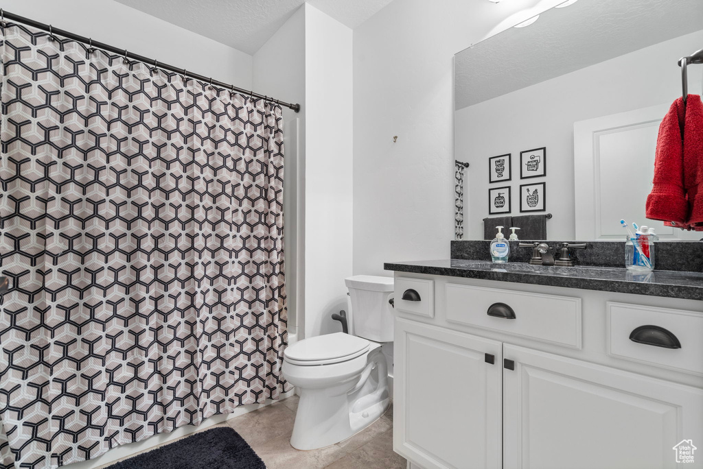 Bathroom featuring tile flooring, vanity, and toilet