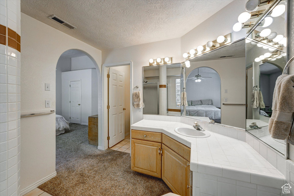 Bathroom featuring tile floors, a textured ceiling, large vanity, and ceiling fan
