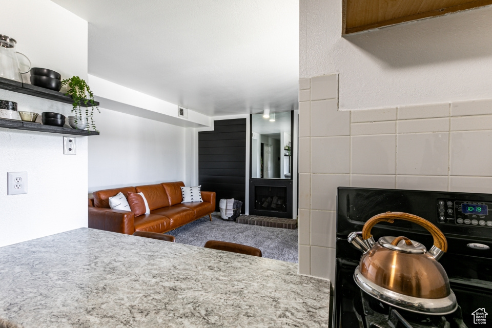 Kitchen featuring carpet and stove