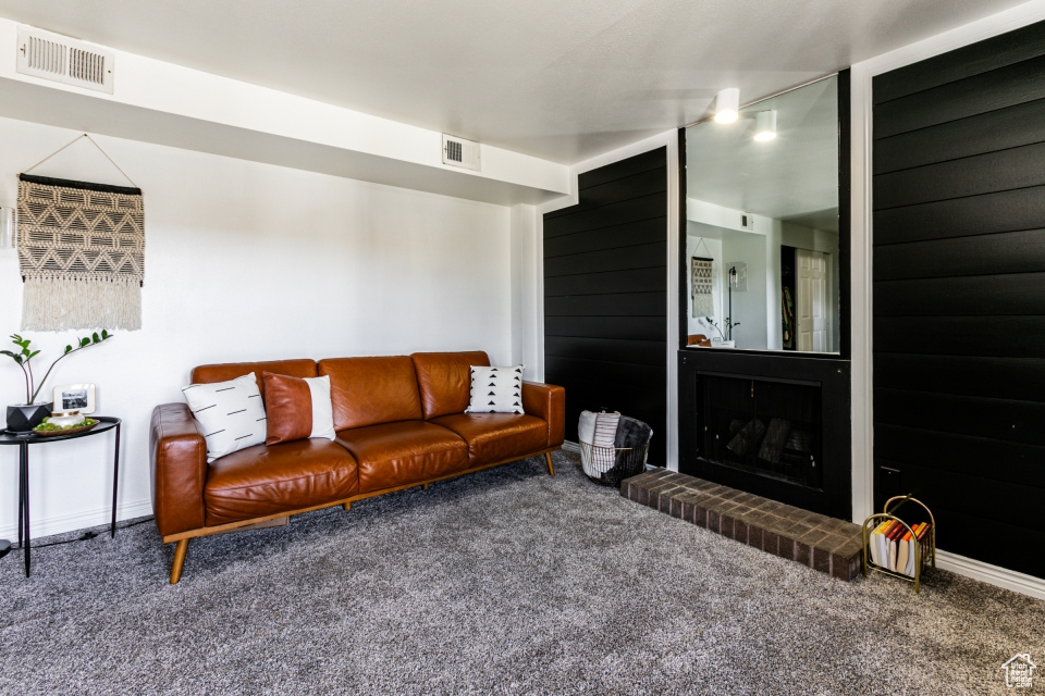 Living room featuring carpet flooring and a brick fireplace