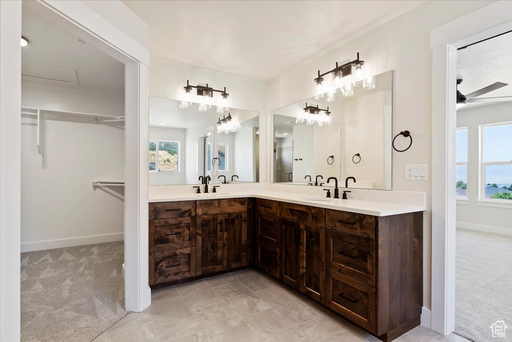 Bathroom with dual bowl vanity, tile patterned floors, and ceiling fan