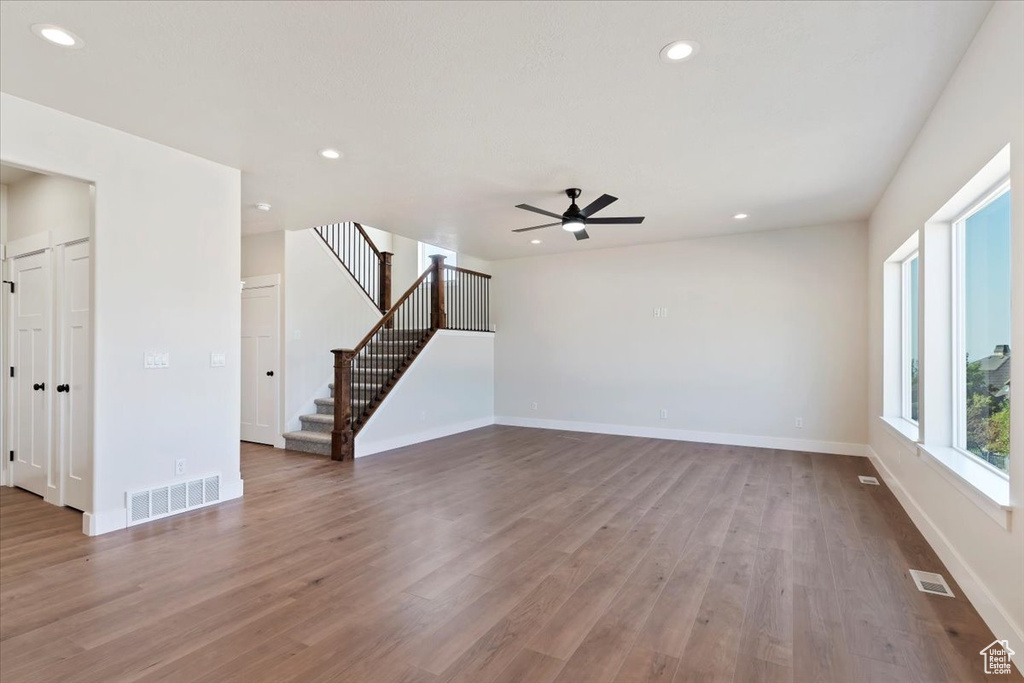 Interior space with ceiling fan and hardwood / wood-style flooring