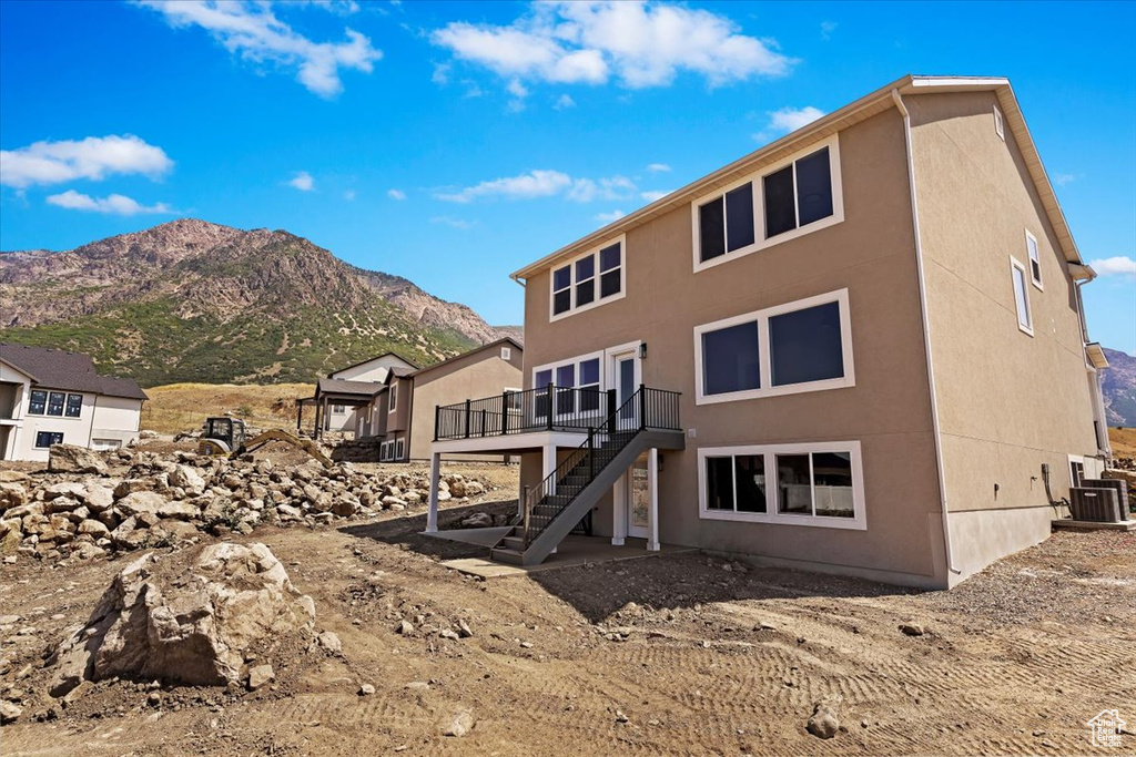 Rear view of house featuring central air condition unit and a deck with mountain view