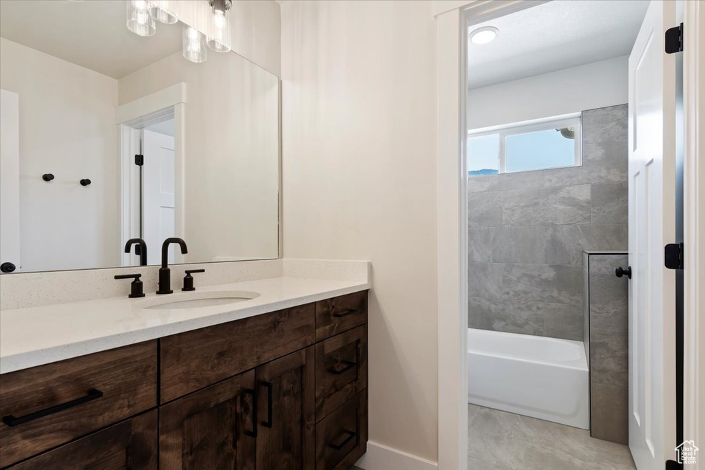 Bathroom with tile patterned floors, vanity, and tiled shower / bath combo