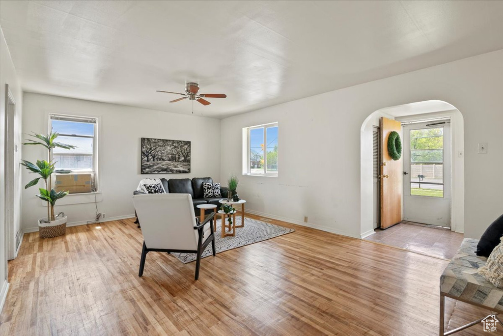 Living room with ceiling fan, a healthy amount of sunlight, and light wood-type flooring