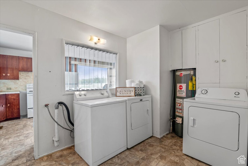 Laundry area with washer hookup, gas water heater, independent washer and dryer, and light tile floors