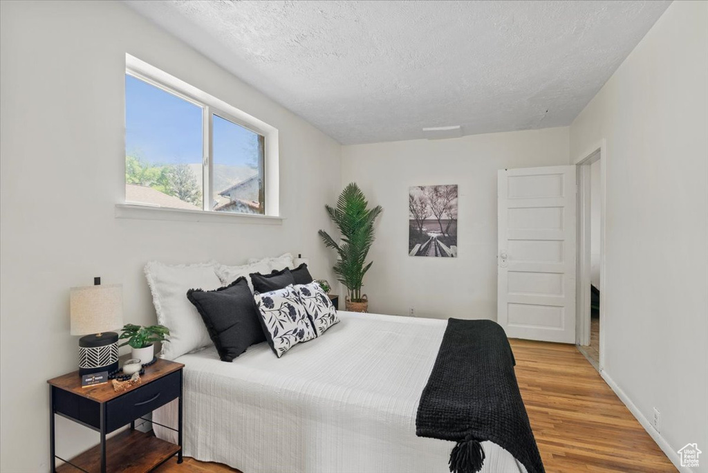 Bedroom featuring a textured ceiling and light wood-type flooring